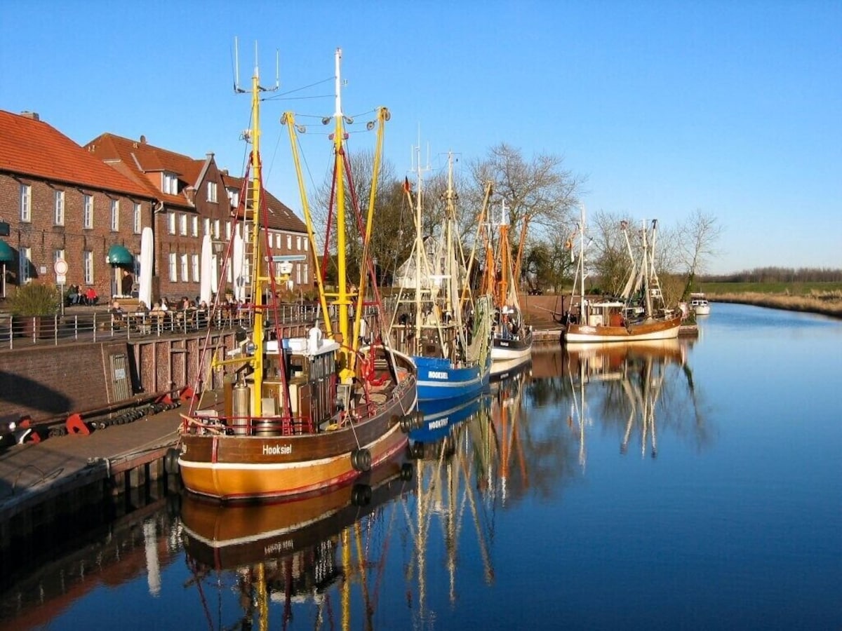 Fischkutter im Hooksieler Hafen bei blauem Himmel